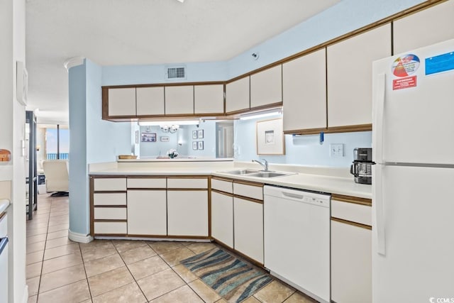 kitchen with light countertops, white appliances, a sink, and white cabinets