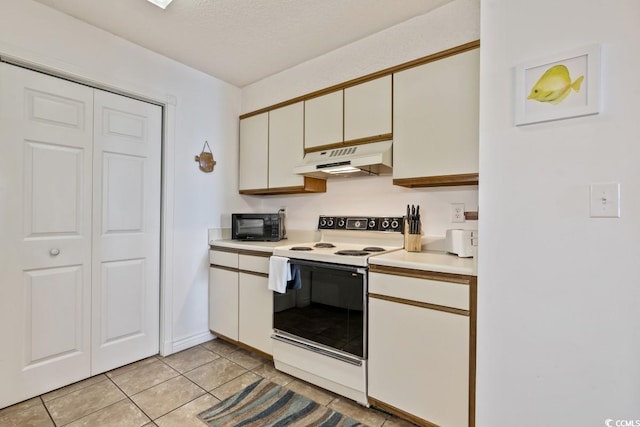 kitchen with black microwave, light tile patterned flooring, under cabinet range hood, light countertops, and white range with electric stovetop