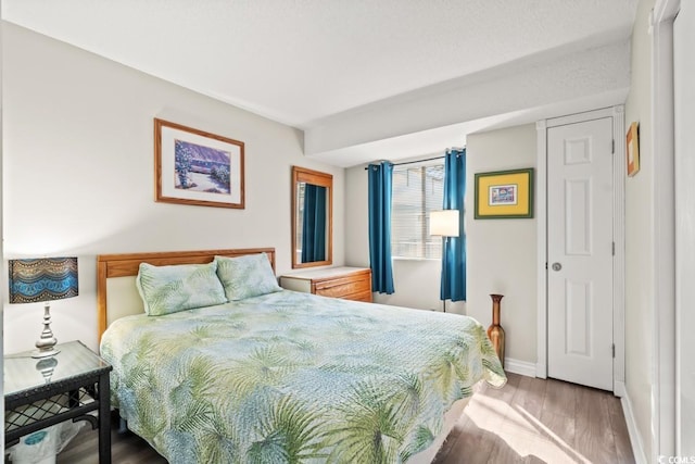 bedroom featuring baseboards and light wood finished floors