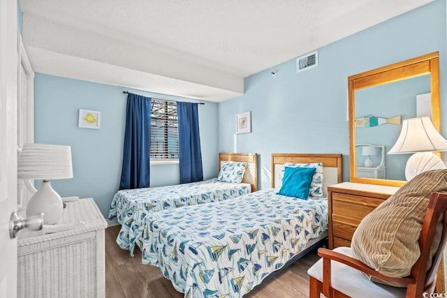 bedroom with visible vents and wood finished floors