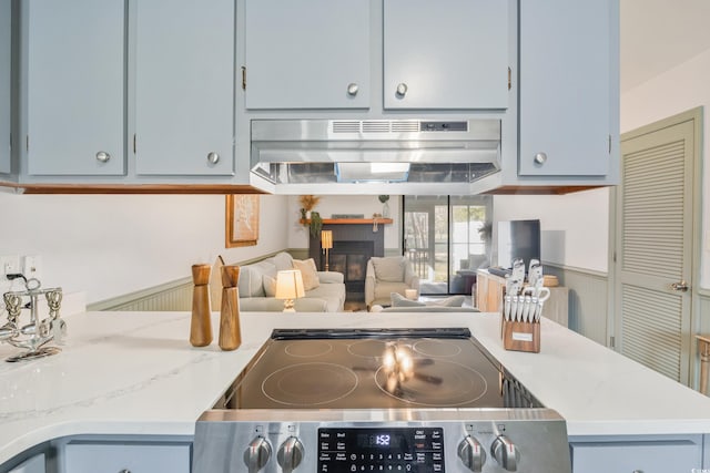 kitchen featuring a glass covered fireplace, open floor plan, stainless steel electric range oven, and extractor fan