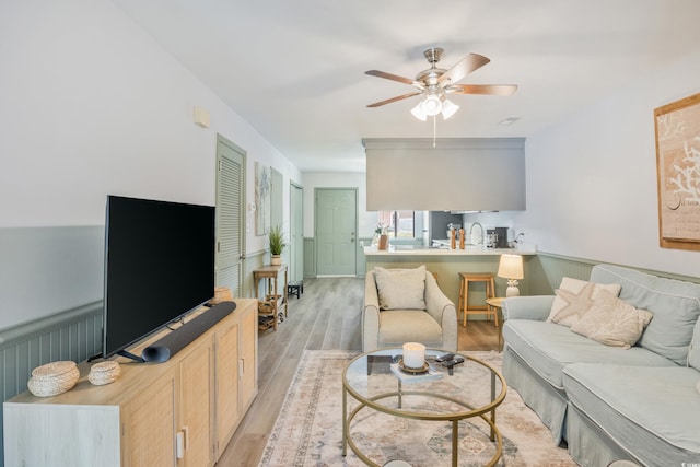 living room featuring a ceiling fan and light wood-style flooring