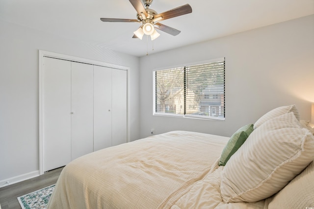 bedroom featuring dark wood-style floors, a closet, and ceiling fan