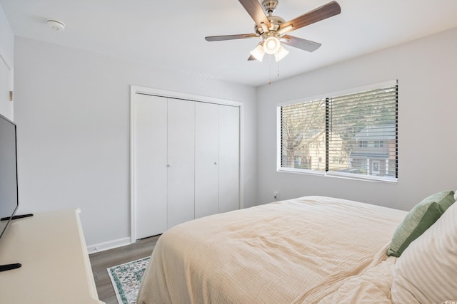 bedroom featuring ceiling fan, a closet, dark wood finished floors, and baseboards