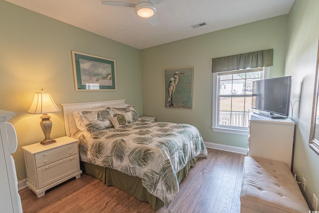 bedroom featuring light wood-type flooring, visible vents, baseboards, and ceiling fan