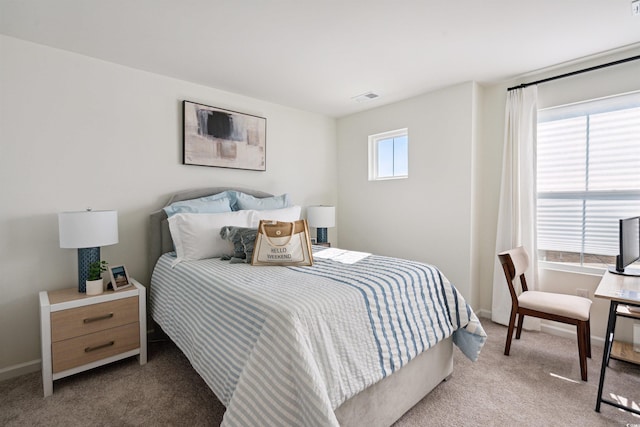 carpeted bedroom with visible vents, baseboards, and multiple windows