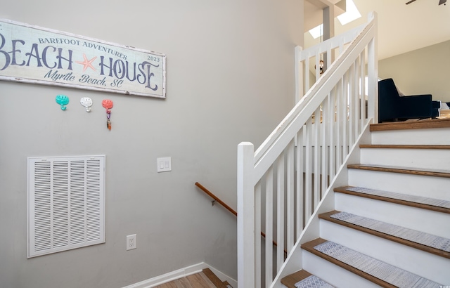 stairway with visible vents and wood finished floors
