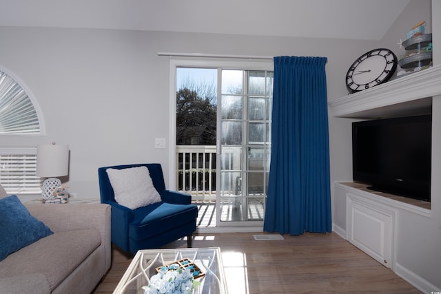 living area featuring visible vents and wood finished floors