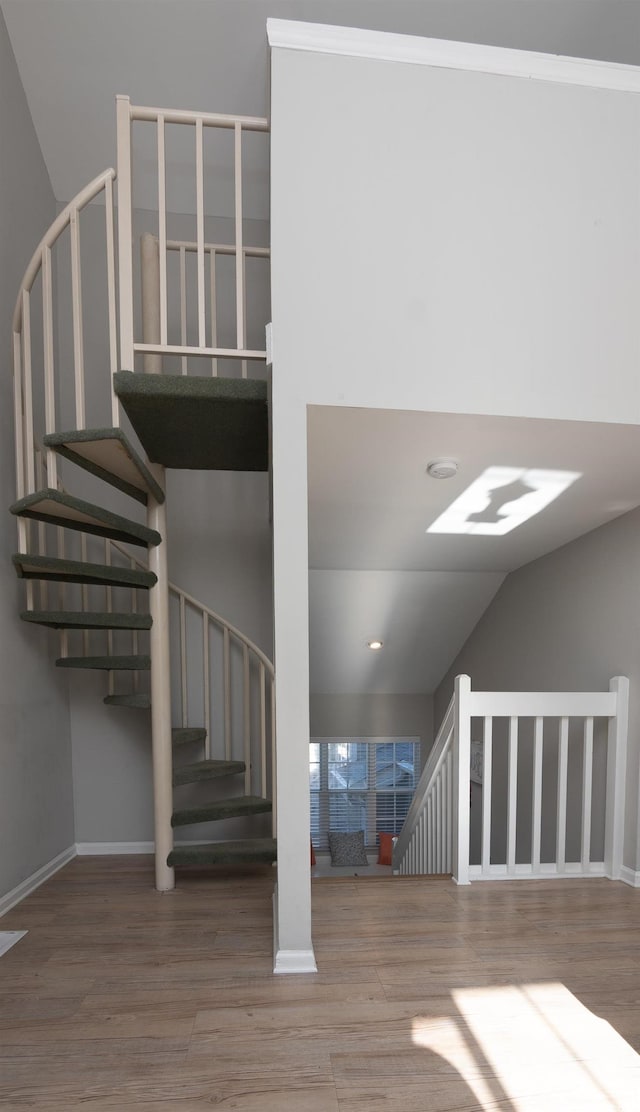 staircase featuring baseboards and wood finished floors