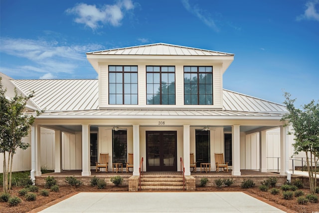 view of front of property with a standing seam roof, a porch, metal roof, and french doors