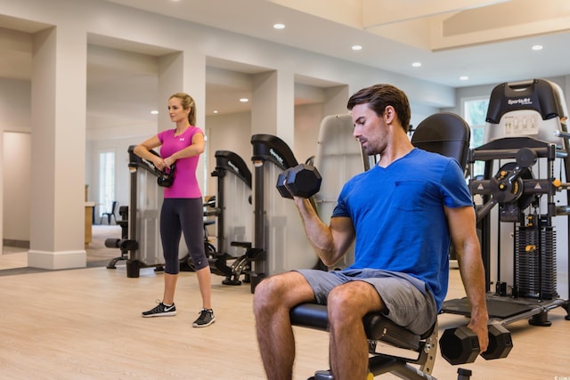 workout room featuring baseboards, recessed lighting, and wood finished floors