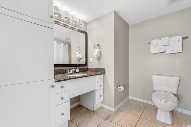 full bath with toilet, tile patterned floors, baseboards, and vanity