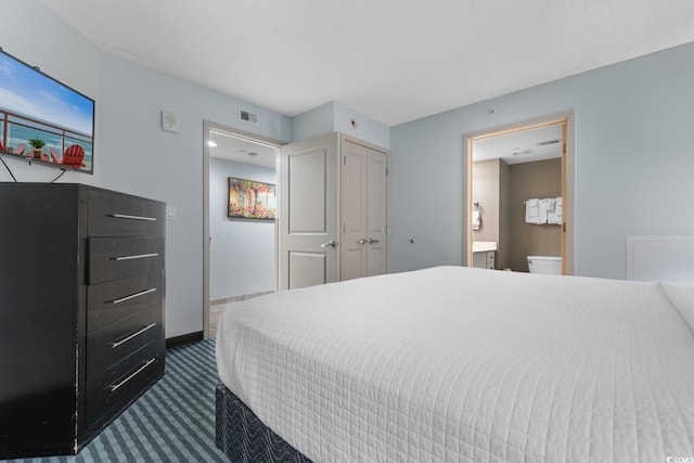 bedroom with ensuite bath, carpet flooring, visible vents, and baseboards