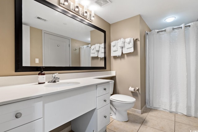 bathroom with toilet, vanity, visible vents, and tile patterned floors