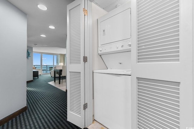 laundry area with carpet floors, stacked washer and clothes dryer, recessed lighting, laundry area, and baseboards