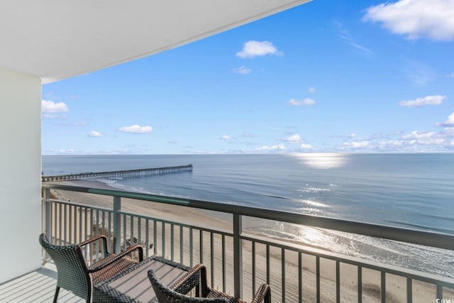 balcony featuring a water view and a beach view