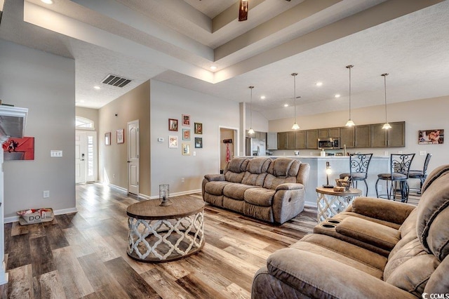 living room featuring visible vents, recessed lighting, baseboards, and wood finished floors