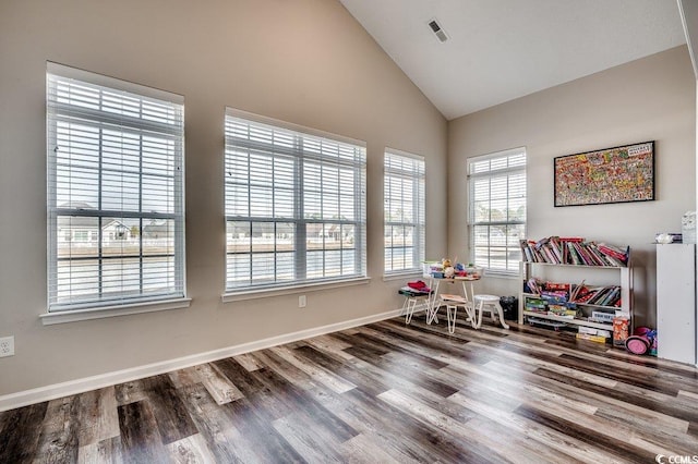 interior space with visible vents, high vaulted ceiling, baseboards, and wood finished floors