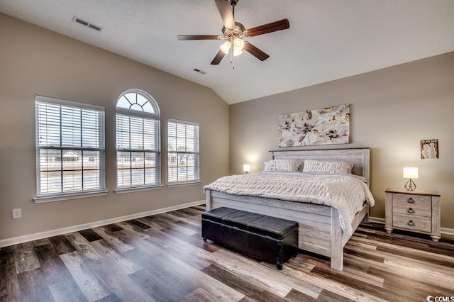 bedroom featuring visible vents, baseboards, wood finished floors, and vaulted ceiling