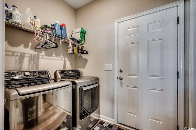 clothes washing area featuring washer and dryer, baseboards, and laundry area