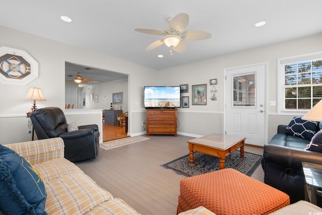 living room featuring a ceiling fan, recessed lighting, wainscoting, and wood finished floors