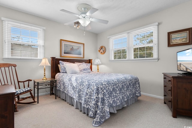 bedroom featuring light carpet, baseboards, and a ceiling fan