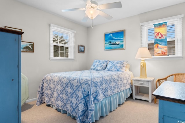 bedroom with ceiling fan, baseboards, and light colored carpet