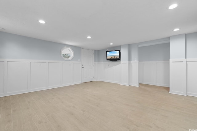 basement with light wood-style floors, recessed lighting, and wainscoting