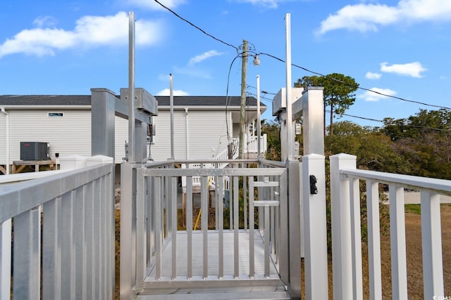 view of gate featuring fence and central AC unit