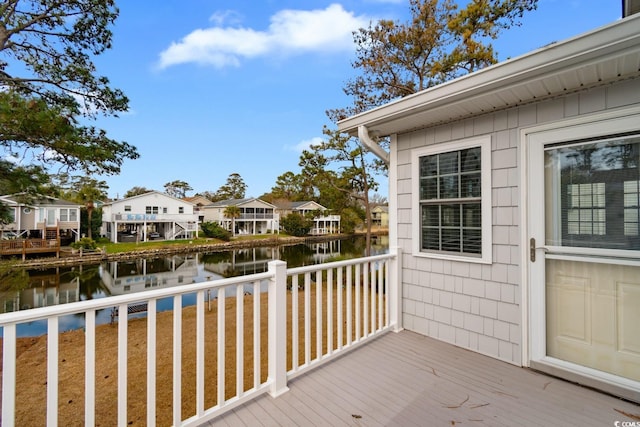 wooden deck with a residential view and a water view