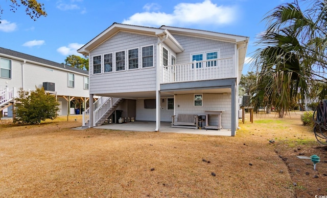 back of property featuring driveway, central AC unit, a lawn, a patio area, and a carport