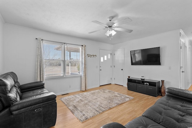 living area with visible vents, ceiling fan, and wood finished floors