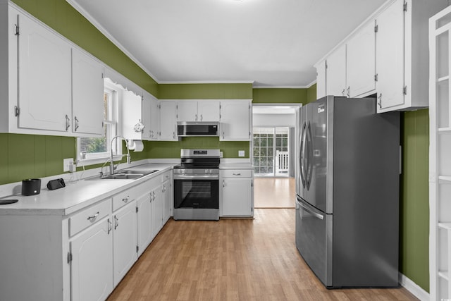 kitchen featuring appliances with stainless steel finishes, white cabinetry, and a sink