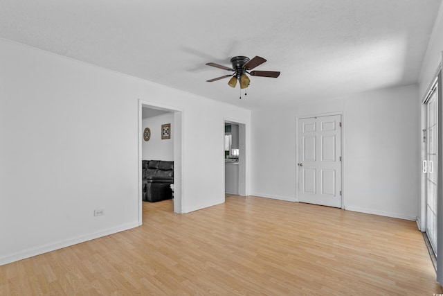 interior space featuring baseboards, a textured ceiling, and light wood finished floors