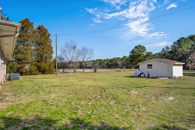 view of yard with central AC and an outdoor structure