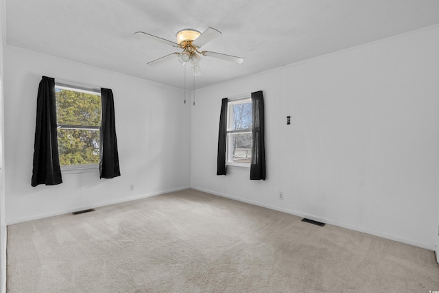 unfurnished room featuring carpet floors, ceiling fan, visible vents, and baseboards