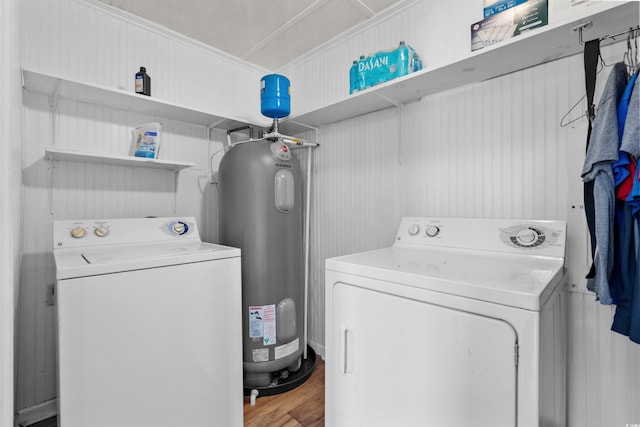 clothes washing area featuring water heater, laundry area, independent washer and dryer, and wood finished floors