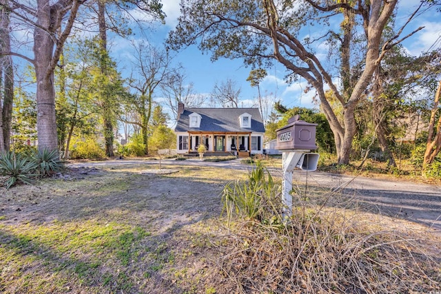 view of front of house with driveway and a chimney