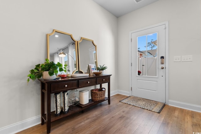 foyer entrance featuring hardwood / wood-style flooring and baseboards