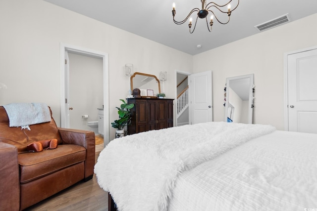 bedroom with light wood-style flooring, ensuite bath, visible vents, and a notable chandelier