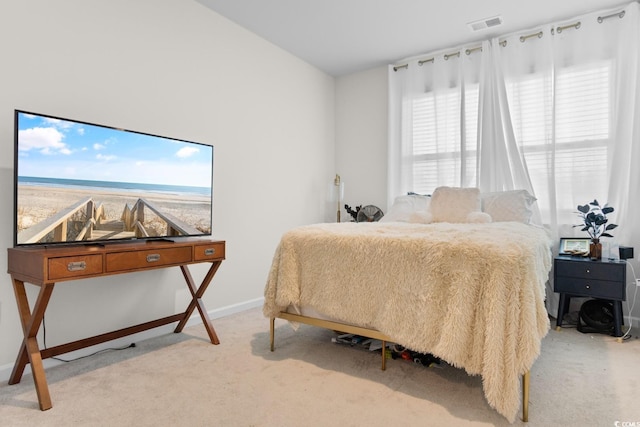 bedroom with light carpet, visible vents, and baseboards