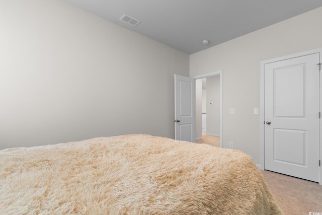 bedroom featuring visible vents and light colored carpet