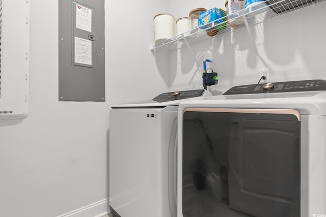 clothes washing area featuring laundry area, electric panel, baseboards, and independent washer and dryer