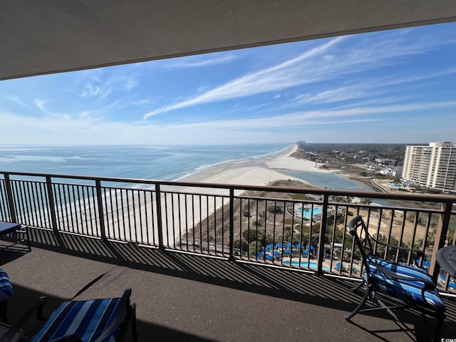 balcony featuring a view of the beach and a water view