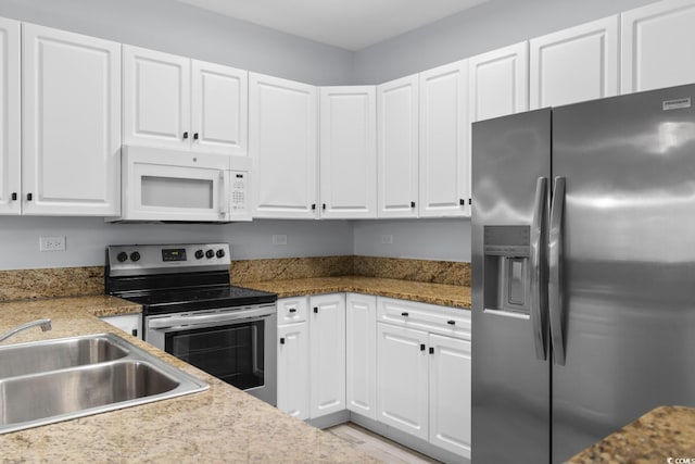 kitchen with stainless steel appliances, white cabinets, and a sink