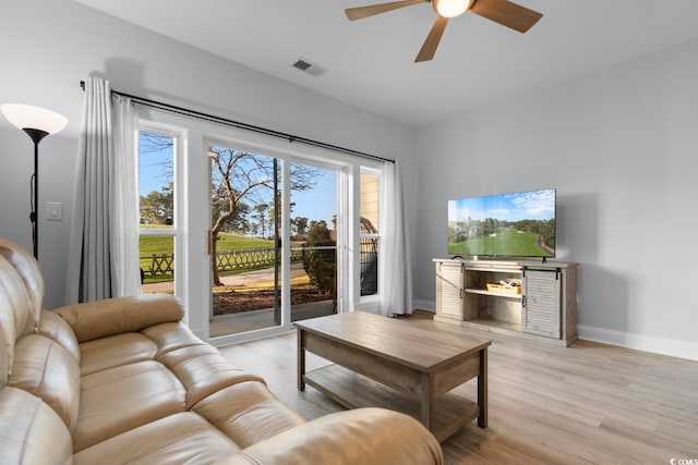 living room with a ceiling fan, baseboards, visible vents, and light wood finished floors