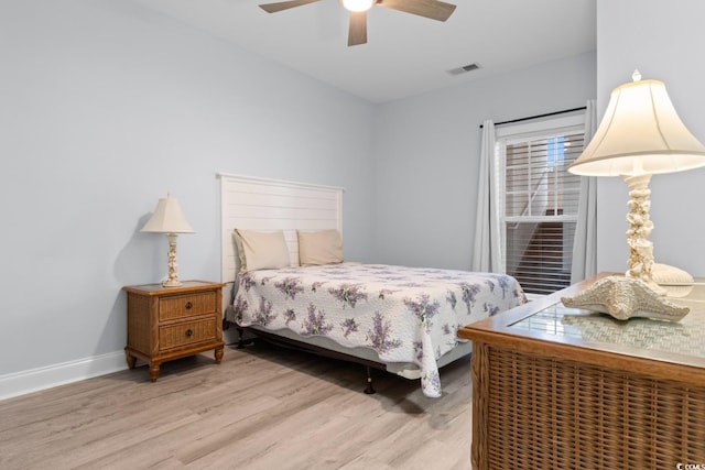 bedroom featuring light wood finished floors, a ceiling fan, visible vents, and baseboards