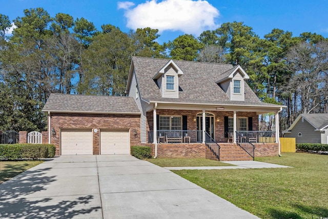 new england style home featuring driveway, covered porch, a front lawn, and brick siding