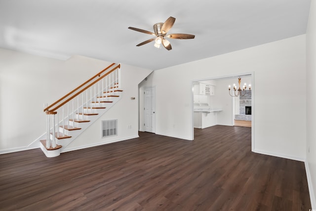 unfurnished living room with ceiling fan, stairs, visible vents, and dark wood-style flooring