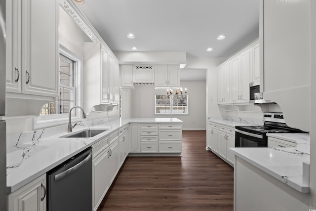 kitchen featuring a peninsula, white cabinetry, stainless steel appliances, and a sink